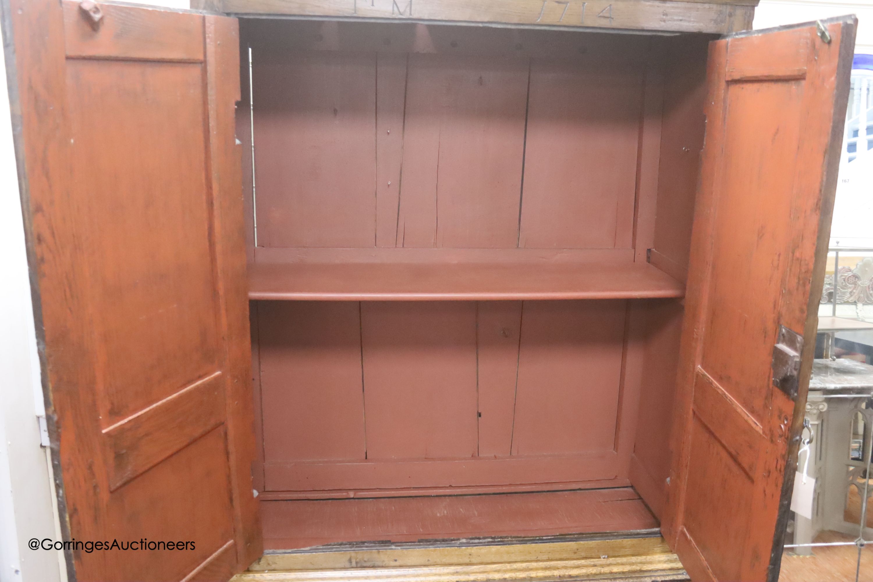 An early 18th century panelled oak press cupboard, dated 1714